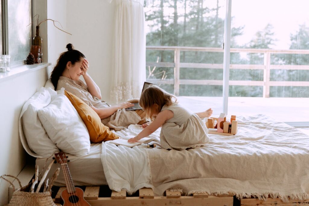 mother working at home with child playing 