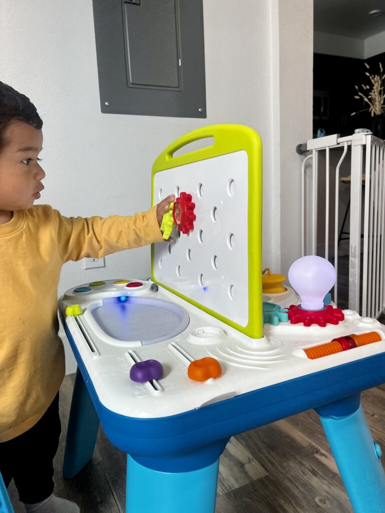 toddler engaging in activity table 