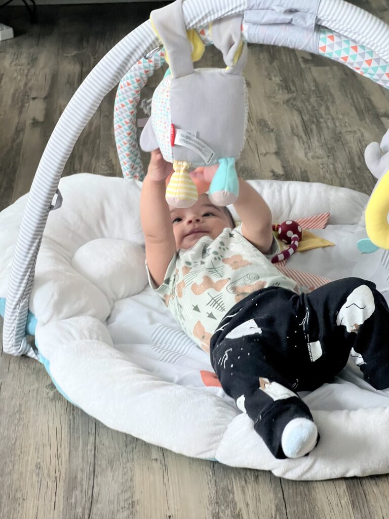 baby on a playmat, while mom works from home  